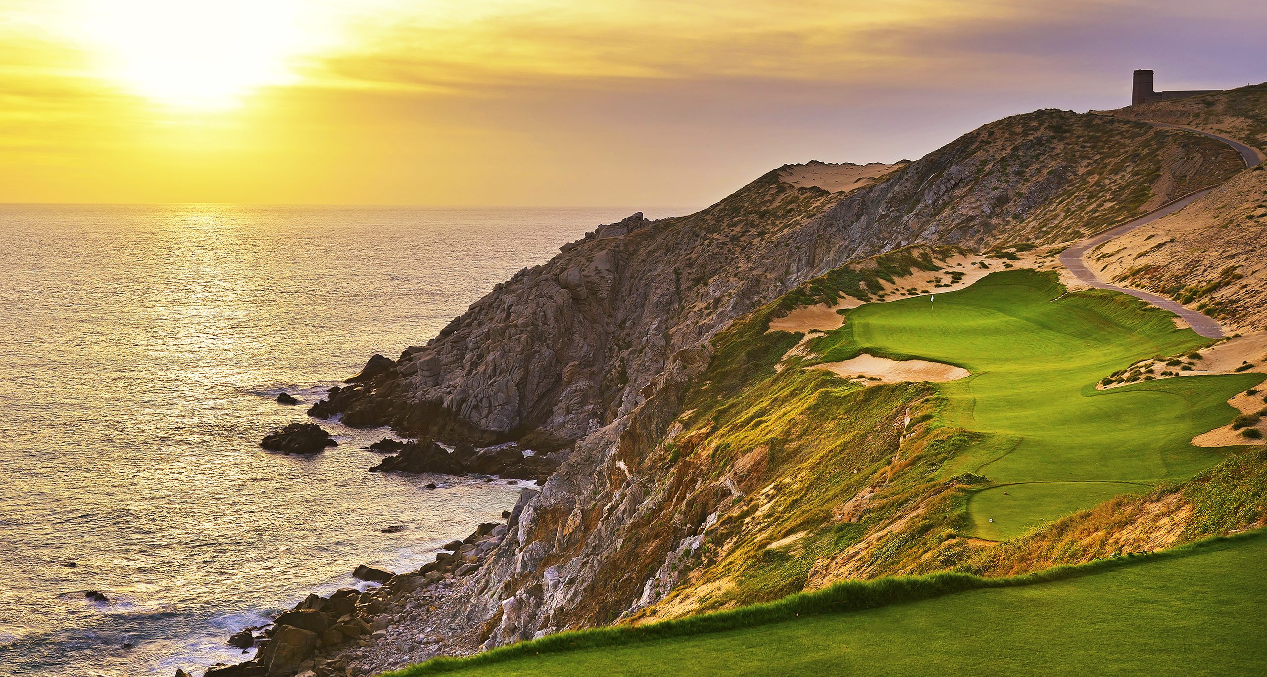Dramatic clifftop golf course at golden hour with ocean views